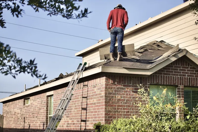 Professional roofer working on a residential roof in Massapequa Park